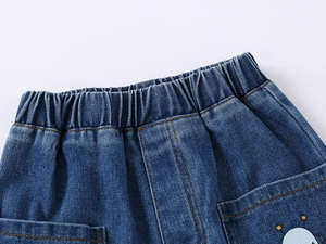 Detail of kids denim shorts featuring elastic waist and cute cartoon robot pocket print