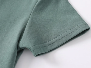 Detailed close-up of bean green polo shirt sleeve with premium double-stitch seam craftsmanship