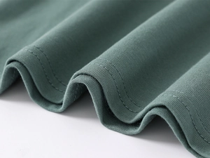 Macro shot of double-needle stitching and soft dark green cotton fabric on kids polo shirt