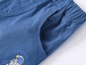 Detail of blue cotton shorts featuring an elastic waist and astronaut cartoon print
