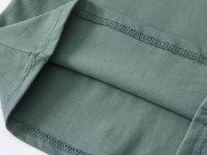 Macro shot of double-needle hem stitching and fine cotton texture on kids polo shirt