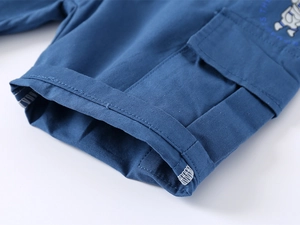 Detail of dark blue boys' cargo shorts with astronaut print and stitched cuff finish