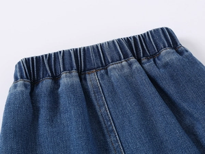 Detail of elastic waist and contrast orange stitching on kids denim shorts