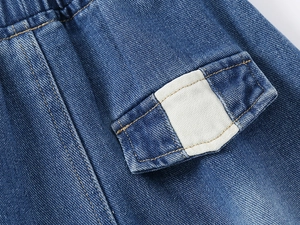 Close-up of boys denim shorts showing elastic waist and cargo pocket stitching