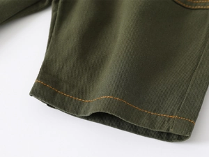 Detail view of army green cotton twill shorts with bright orange contrast stitching