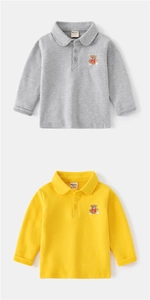 Detail of grey and yellow kids' polo shirts featuring delicate bear embroidery and soft cotton