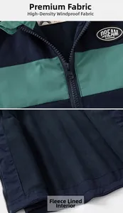 Detail of windproof color-block jacket showing high-density fabric and warm fleece lining
