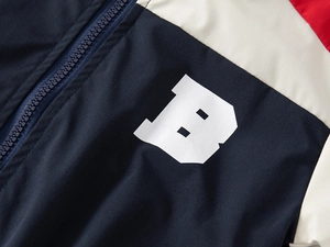 Detailed close-up of color-block windbreaker jacket with B-letter print and resin zipper