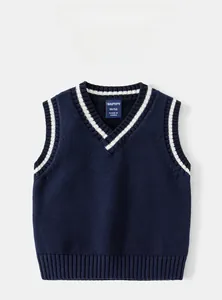 Détail du gilet en maille bleu marine à col en V avec rayures blanches et étiquette