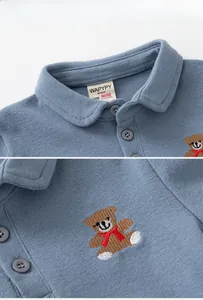 Close-up of baby polo shirt collar with neat buttons and cute bear embroidery detail