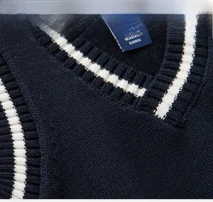 Détail du gilet en maille bleu marine avec côtes blanches et texture fine