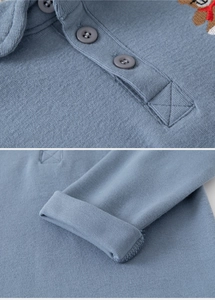 Detail of blue cotton long sleeve Polo shirt featuring rib-knit cuffs and three-button placket