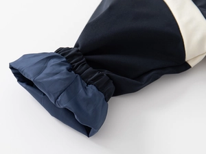 Detail of elastic ribbed cuff on navy blue boys sports jacket with contrast beige stitching
