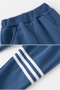 Detail of blue knit jogger pants featuring elastic waistband and white side stripes