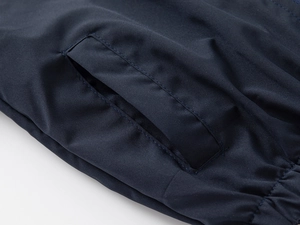 Detail of side pocket on navy blue windbreaker jacket with premium stitching and texture