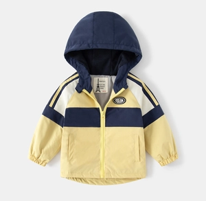 Detail of color-block hooded jacket showing the DREAM patch and ribbed windproof cuffs