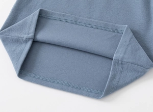 Close-up of double-needle stitching and soft blue knit texture on children's polo shirt