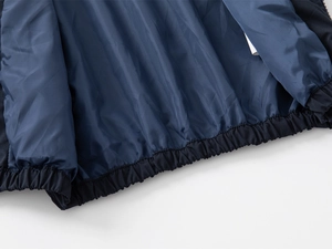 Detail of navy blue boys' jacket featuring elastic hem and smooth polyester lining