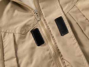 Detailed macro view of children's hooded windbreaker zipper and black velcro fasteners