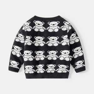 Detailed view of children's knit sweater featuring white bear patterns and ribbed cuffs