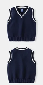 Détail d'un gilet en tricot bleu marine pour garçons avec rayures blanches sur les bords