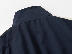 Detail view of boys sportswear jacket with navy and beige contrast panel and collar stitching