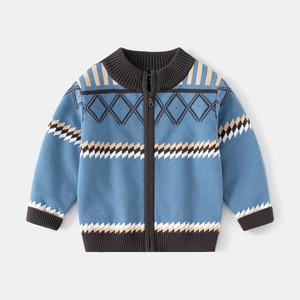 Détail d'un cardigan pour garçon avec motifs géométriques bleus et fermeture zippée