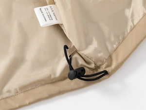 Detail of children's windbreaker lining with care label and adjustable drawstring