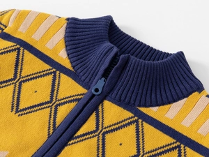 Détail de col montant zippé avec motif en tricot losanges jaune moutarde et bleu marine