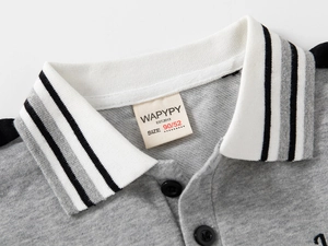 Détail du polo gris pour enfant avec col rayé, étiquette tissée et bouton noir