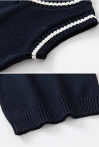 Détail du gilet en maille bleu marine avec col en V et rayures blanches classiques