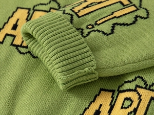 Detailed close-up of thickened ribbed cuffs on green knitted sweater with ART jacquard