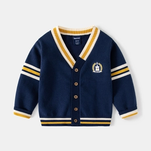 Detail of navy knit cardigan featuring yellow striped ribbing and crest embroidery