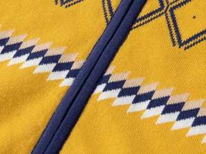 Détail de cardigan tricoté pour garçon avec fermeture éclair et motif losanges jaune