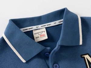 Detail of baby polo shirt with mist blue knit fabric and woven logo brand neck label