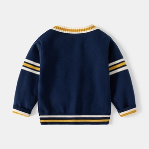 Detail of navy knit cardigan featuring yellow and white striped ribbed cuffs and hemline