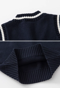 Détail du gilet en tricot bleu marine avec col en V rayé et ourlet côtelé doux