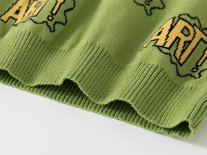 Detailed view of green knitted sweater featuring ART! jacquard and ribbed hem texture