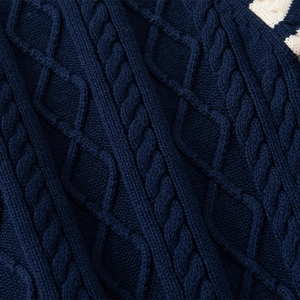 Macro shot of navy blue cable knit and diamond pattern on warm children's sweater