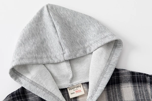 Detail view of boys hooded plaid shirt showing gray jersey hood and brand size label 90