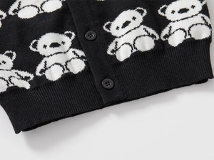 Detail of knit cardigan showing jacquard bear patterns and black round buttons