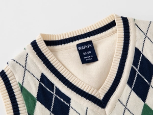 Dettaglio dello scollo a V con motivo a rombi blu e verde su gilet in maglia per bambini