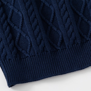 Detail of navy blue knit sweater featuring cable knit texture and ribbed hem for boys