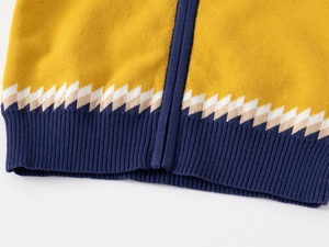 Détail d'un pull pour garçon avec corps jaune moutarde et bordure côtelée bleu marine
