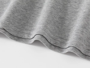 Gros plan sur l'ourlet du polo en maille grise avec des détails de double couture
