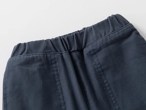 Détail de la taille élastique et de la texture sergé sur le pantalon bleu pour enfant