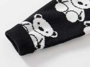 Macro detail of elastic ribbed cuffs and bear jacquard pattern on kids knit sweater