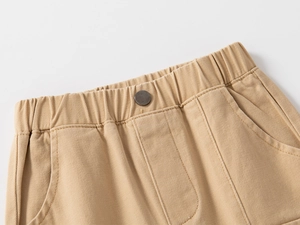 Dettaglio macro della vita di pantaloni in cotone kaki con elastico e bottone metallico