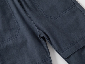 Gros plan détaillé des coutures renforcées de l'entrejambe et du tissu du pantalon enfant