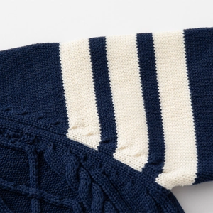 Detailed view of navy and white cable knit texture on a boys' knit sweater